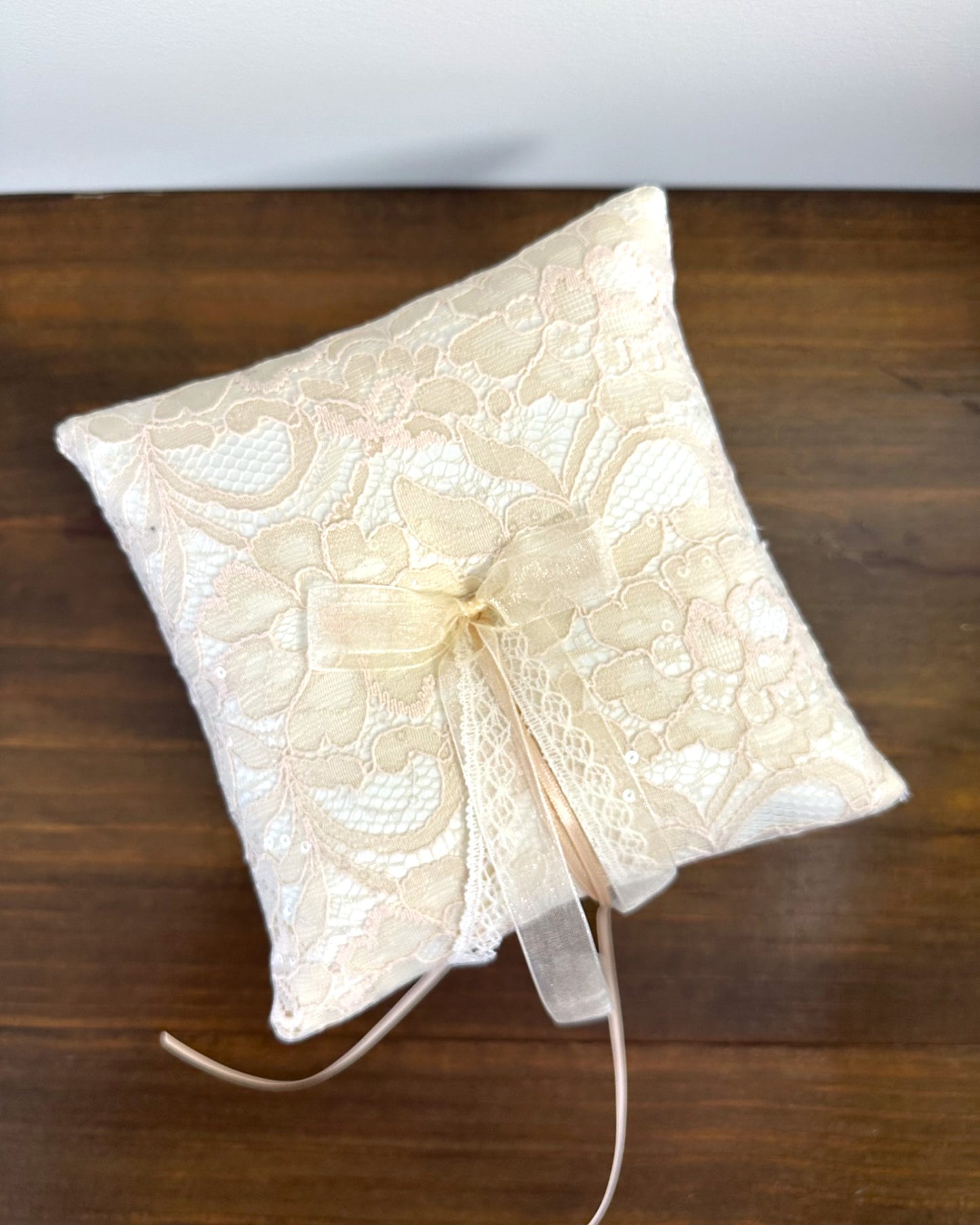 Almofadinha para alianças em cetim offwhite com renda champagne e fitas. Modelo Adelaide da Etiquette, tradicional e sofisticado.