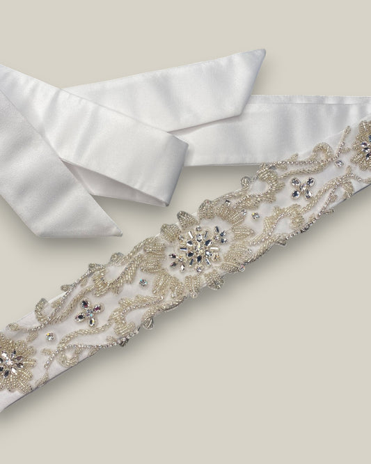 Cinto para noiva em tecido de cetim encorpado com aplicação de bordado em cristais e miçangas na cor prata. Bordado&nbsp;mede 22 cm e o comprimento total do cinto é de 230 cm.