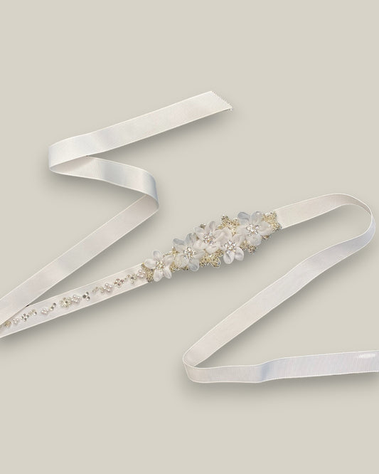 Cinto para noiva confeccionado em fita de gorgorão branco com aplicação de flores em metal com cristais e flores de tecido na cor branca com detalhe em cristais.