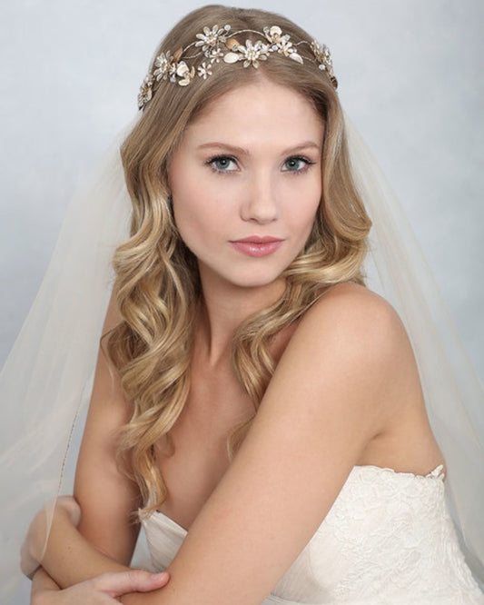 Headband para noivas com flores em metal 3D e detalhes de cristal que explodem ao longo de uma faixa de metal flexível e entrelaçado.