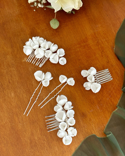 Diversos tamanhos de pentes e pins para noivas com mini flores em porcelana branca.
