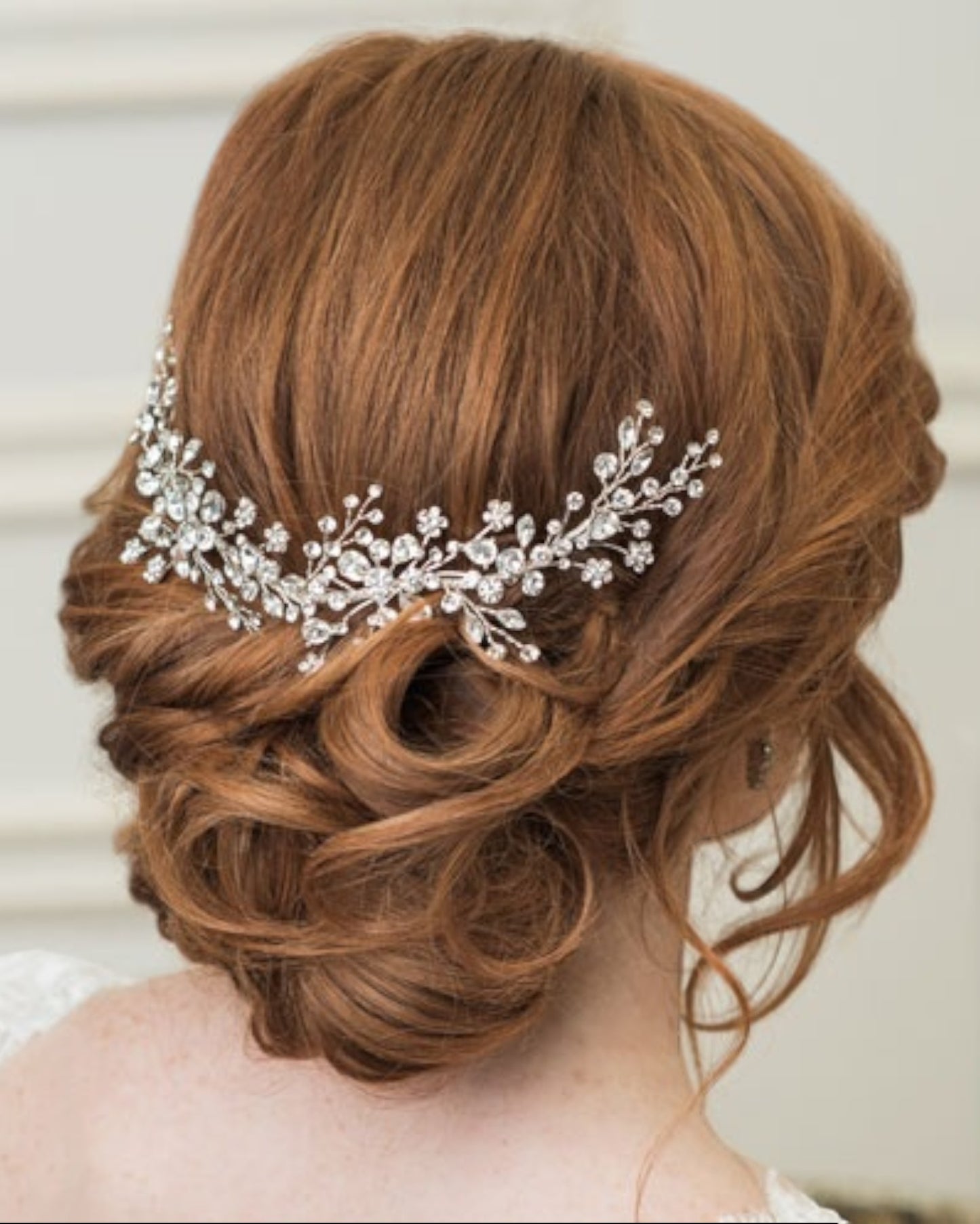 Delicado pente para noiva com base em metal banhado em prata e raminhos com cristais.