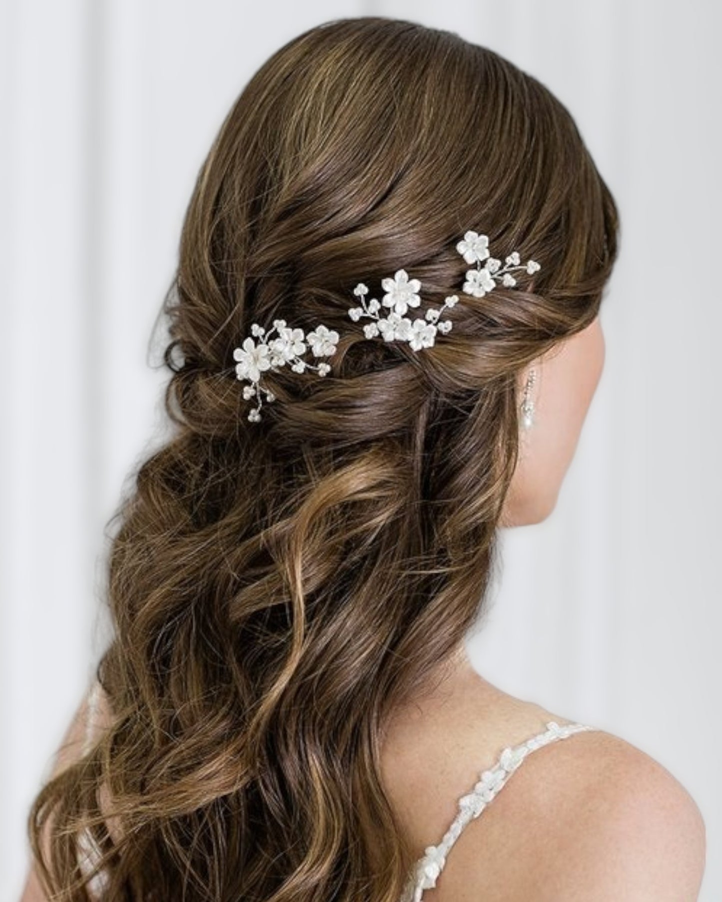 Conjunto de três delicados e diferentes pins com flores de porcelana e ramos de pérolas.