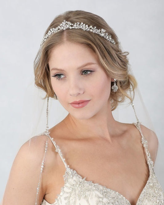 Delicada e romântica tiara para noivas estruturada em metal flexível banhada em prata com aplicação de cristais em formatos redondos e de gota.