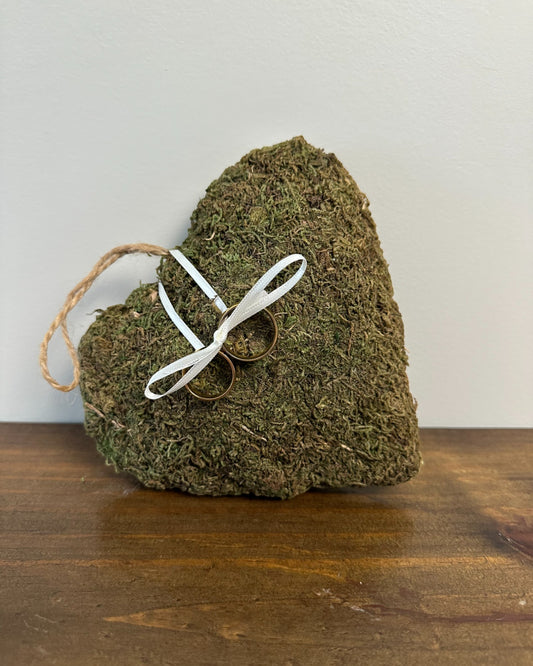 Porta alianças da Etiquette em formato de coração revestido com graminha sintética, com alça de corda e fitinha para prender alianças.