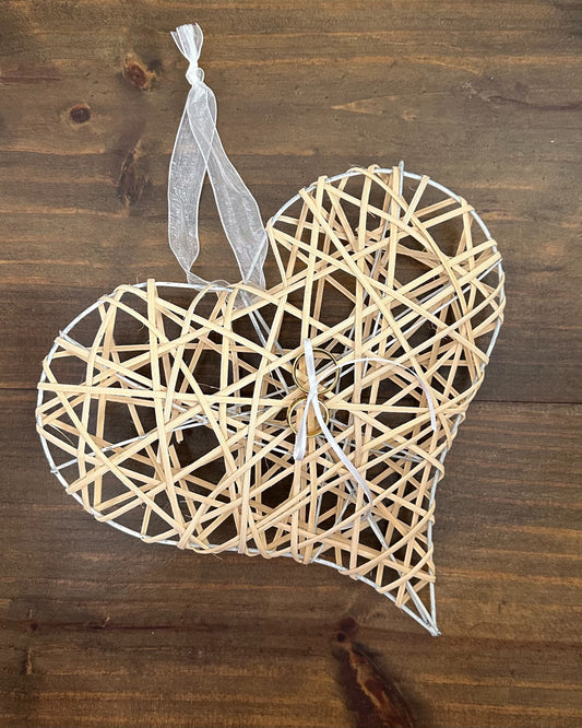 Porta alianças da Etiquette em formato de coração moderno com estrutura metálica e ripas de madeira. Com fitinha e alça para carregar.
