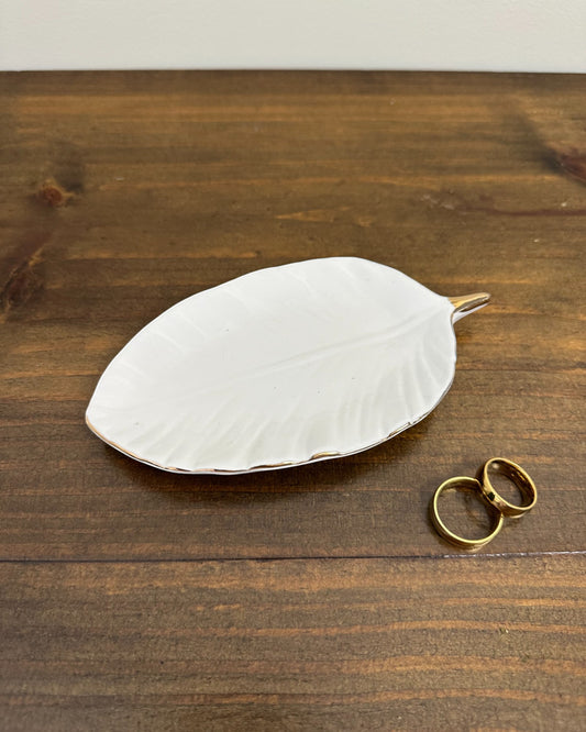 Porta alianças da Etiquette em porcelana vitrificada com formato de folha e detalhe dourado. Perfeito para casamentos pequenos e elegantes.