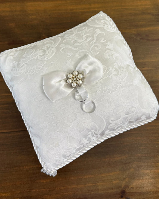 Almofadinha brocado da Etiquette com laço central de pérolas e cristais, fitas para alianças e franjas nas pontas. Modelo clássico e sofisticado.