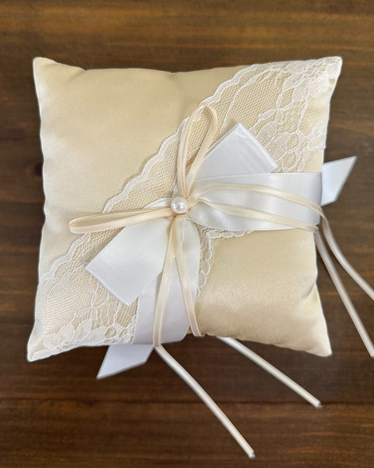 Almofadinha para alianças em cetim champagne com detalhe em renda e laço central. Modelo clássico e delicado da Etiquette.