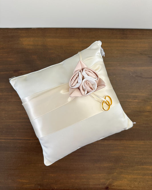 Almofadinha de alianças bege com três flores em cetim champagne e franjas nas pontas. Modelo delicado da Etiquette para casamentos elegantes.