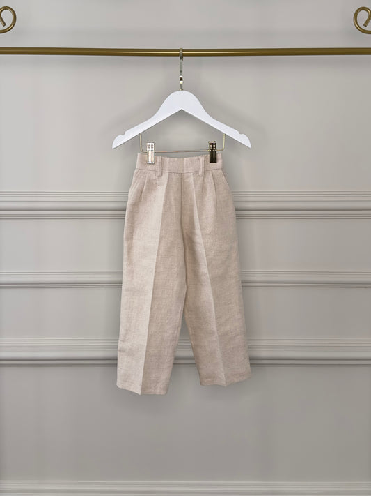 Calça infantil bege claro da Edição Consciente Etiquette, com textura natural e leve, ideal para looks de pajens em casamentos ao ar livre.