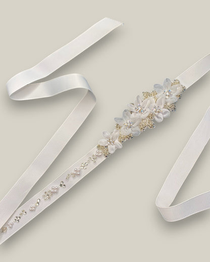 Cinto para noiva confeccionado em fita de gorgorão branco com aplicação de flores em metal com cristais e flores de tecido na cor branca com detalhe em cristais.