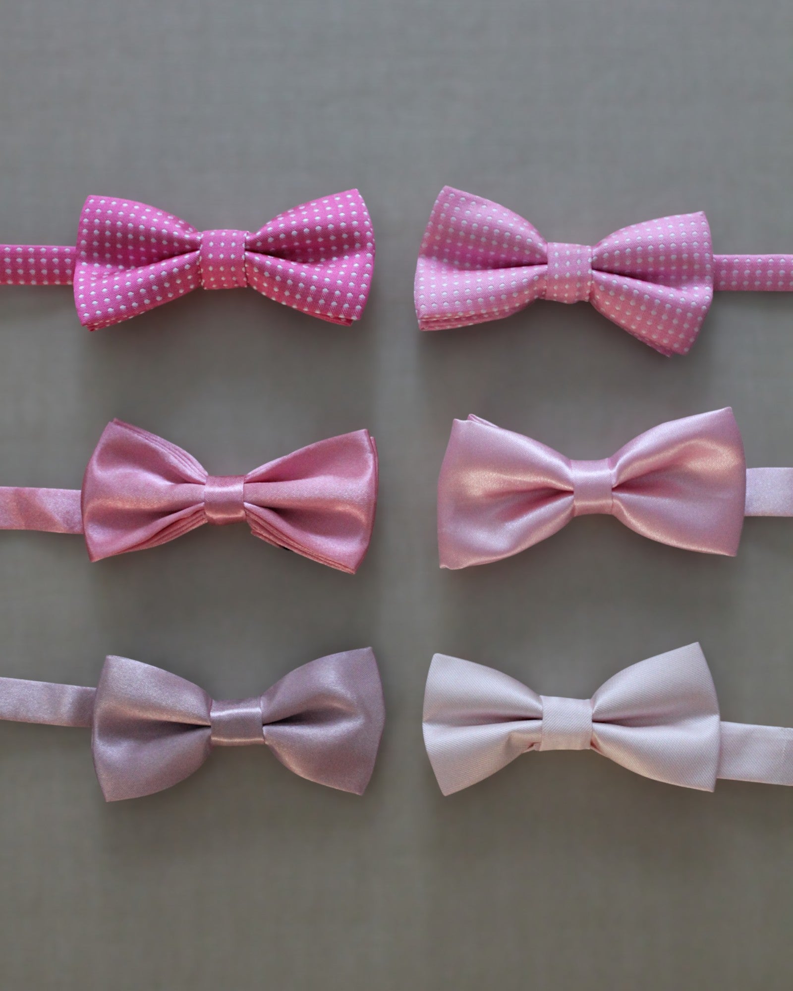 Gravatinha borboleta infantil em cetim nos tons de rosa, com regulagem ajustável. Acessório delicado para pajens.