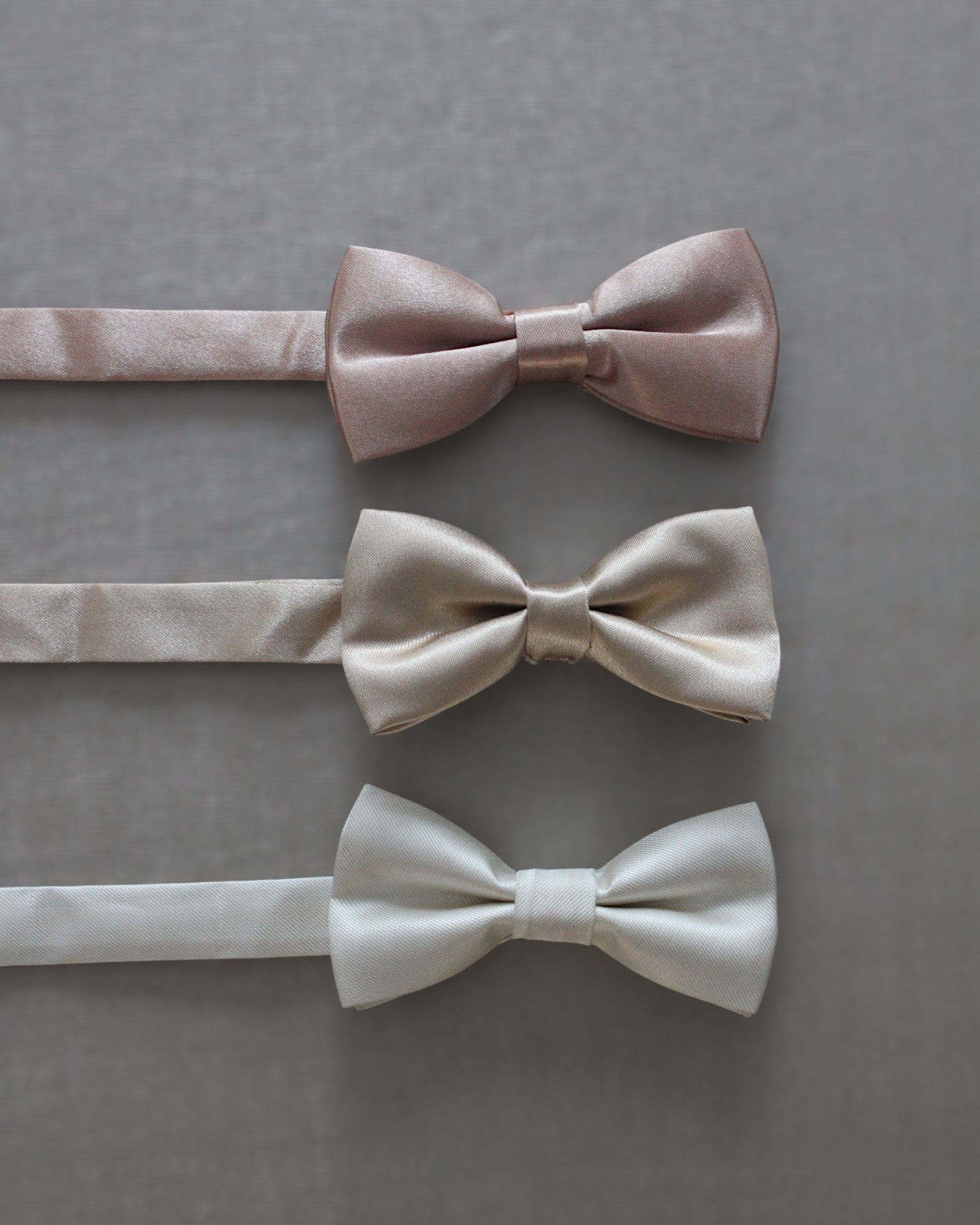 Gravatinha borboleta infantil em cetim nos tons offwhite e champagne. Modelo regulável para pajens em cerimônias clássicas.