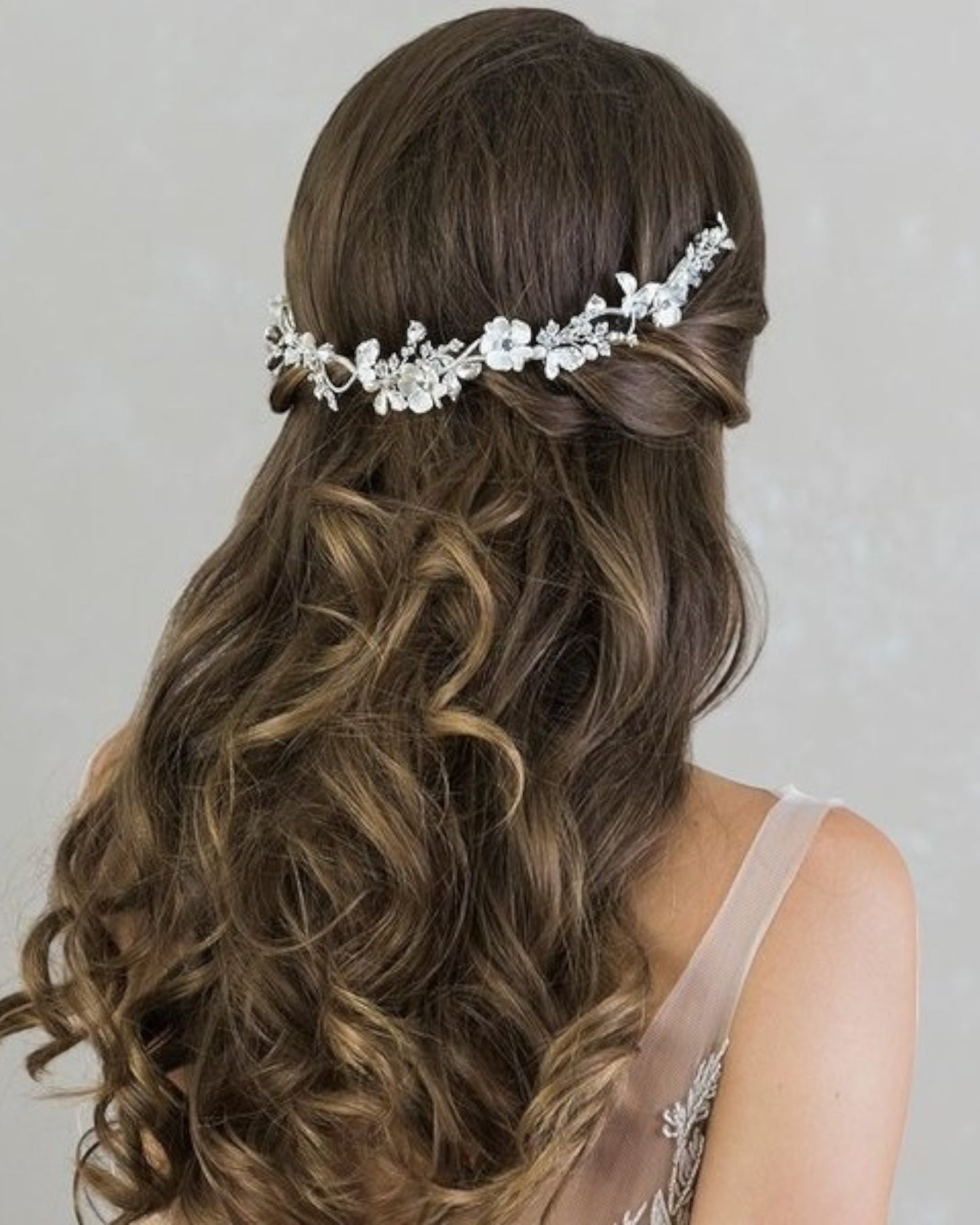 Delicada tiara flexível com flores e folhas em metal e banhadas em prata. Pode ser usada como um pente na parte de trás do penteado.