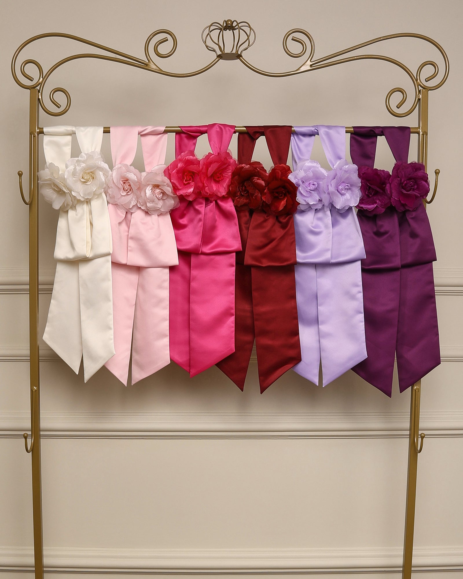 Faixa de cintura com flores em cetim da Etiquette, com broche floral e velcro, disponível para aluguel junto aos vestidos infantis