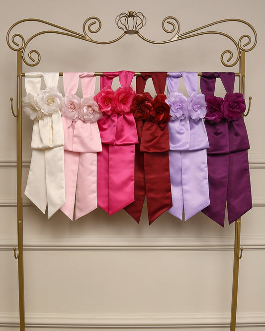 Faixa de cintura com flores em cetim da Etiquette, com broche floral e velcro, disponível para aluguel junto aos vestidos infantis