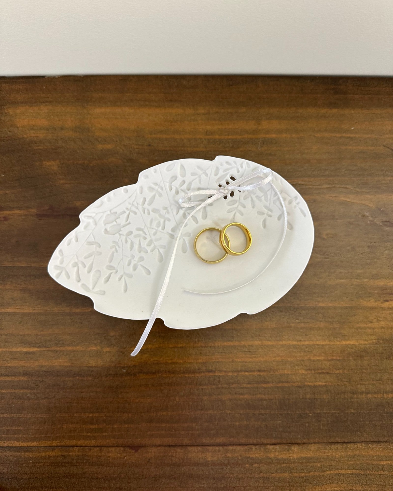 Porta alianças da Etiquette em porcelana branca matte, com formato de folha. Modelo delicado e moderno para cerimônias românticas.