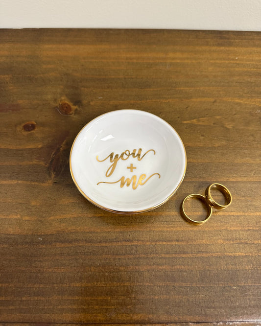 Pratinho porta-alianças da Etiquette em porcelana vitrificada com borda e escrita dourada “You + Me”. Romântico e moderno.